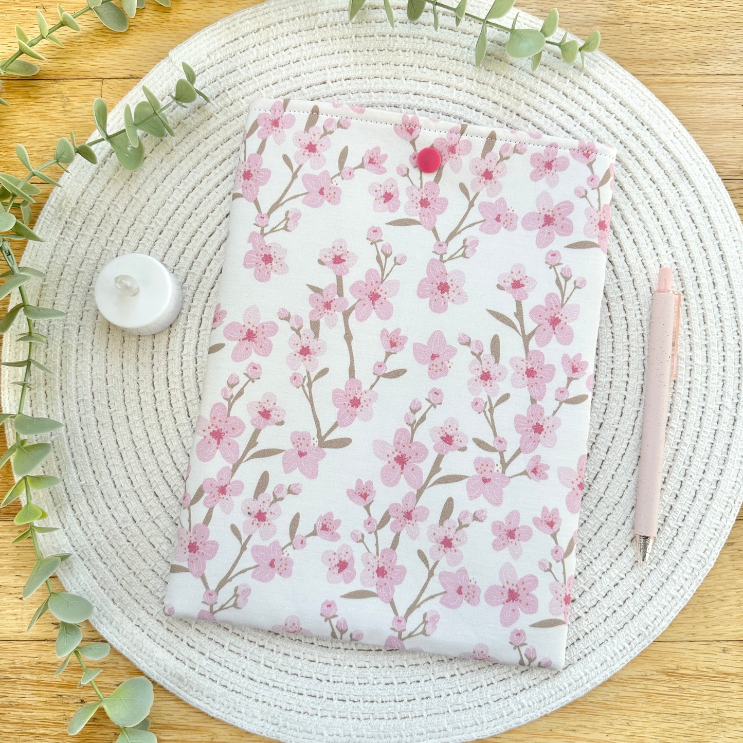 cherry blossom book sleeve on woven mat with decorative elements