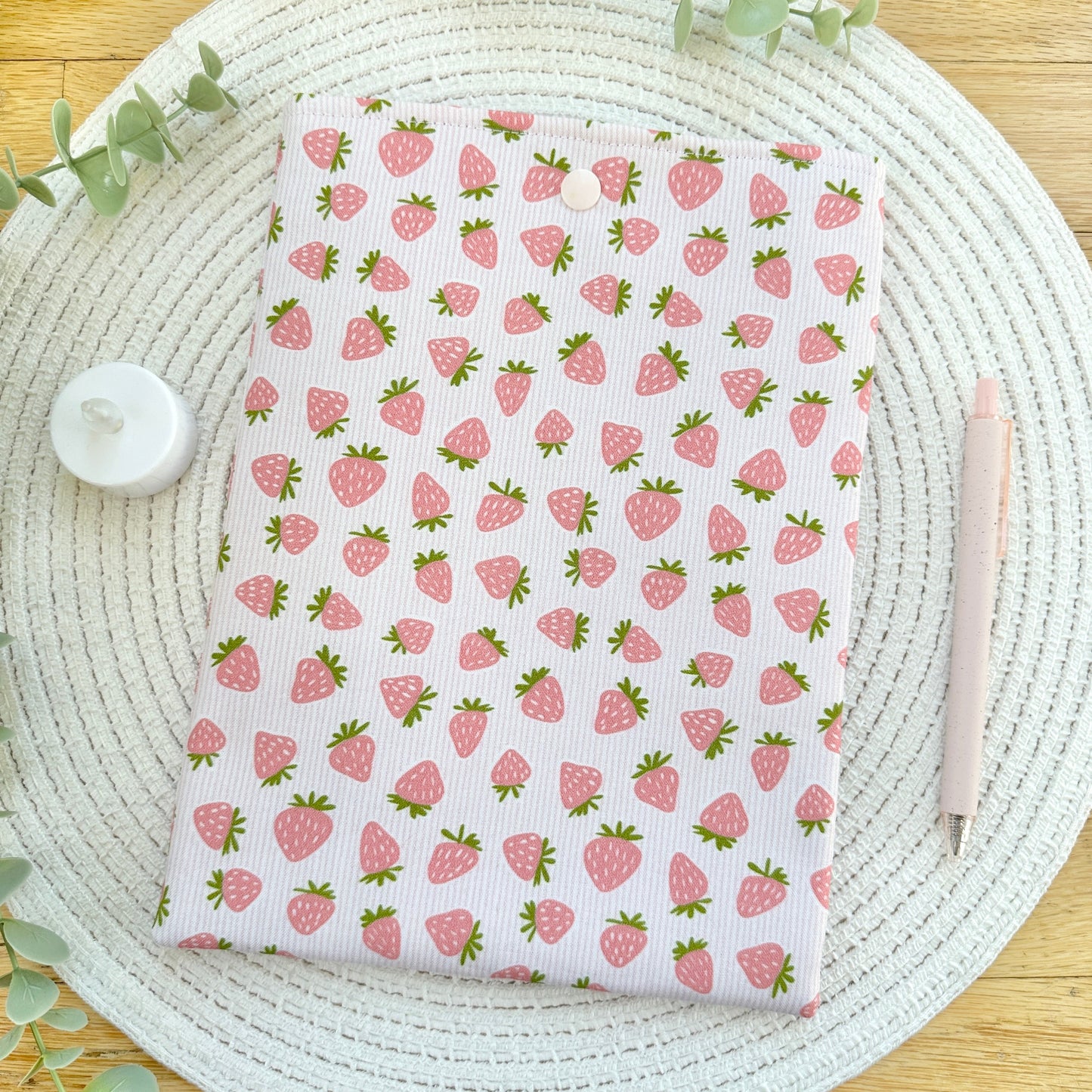 strawberry cotton book sleeve for readers on woven mat with decorative elements