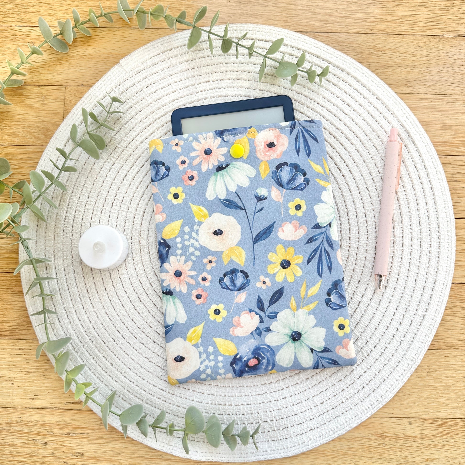 blue floral e-reader sleeve with kindle on woven mat