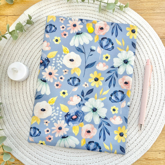 blue floral book sleeve on woven mat with decorative elements
