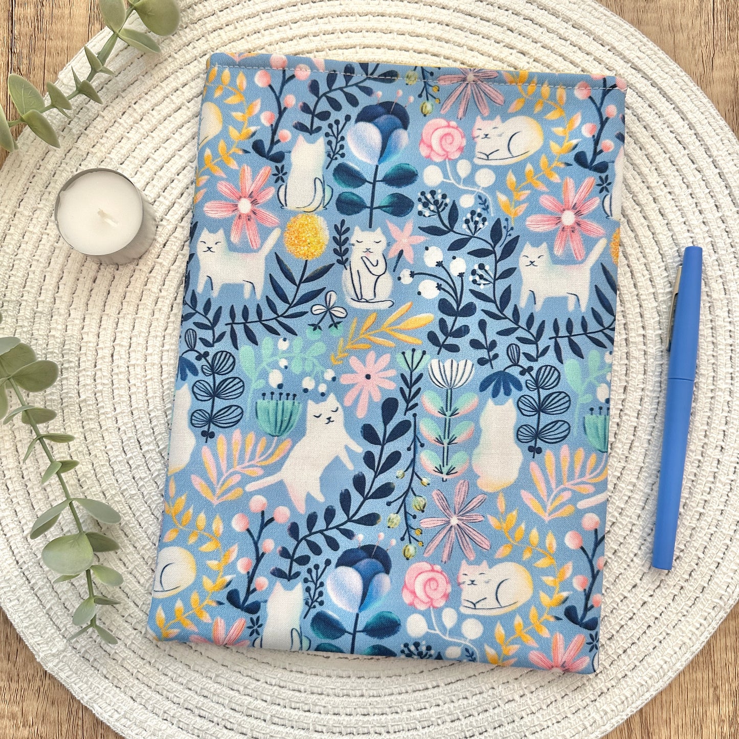book sleeve with floral and cat pattern on a woven mat
