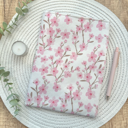 Floral-patterned book sleeve on a woven mat