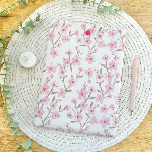 cherry blossom book sleeve on woven mat with decorative elements