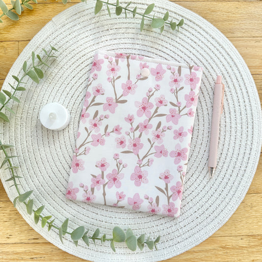 cherry blossom e-reader sleeve on table with pen and candle