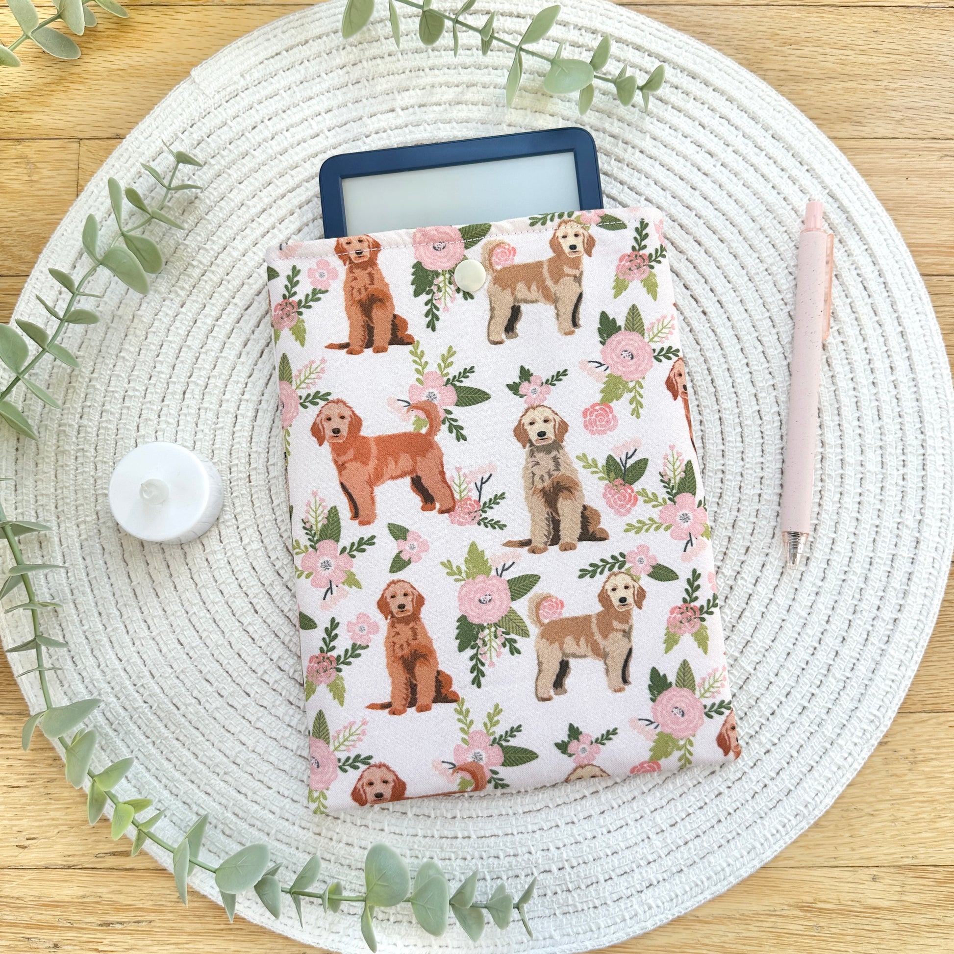 floral- and dog-patterned e-reader sleeve on woven mat with decorative elements