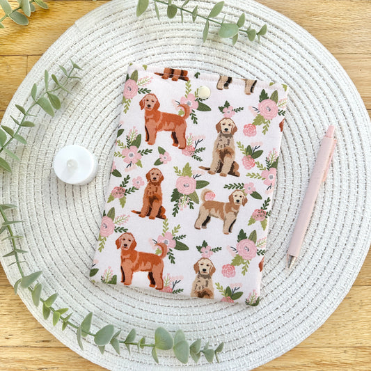 floral and puppy themed e-reader sleeve on table with greenery and pen
