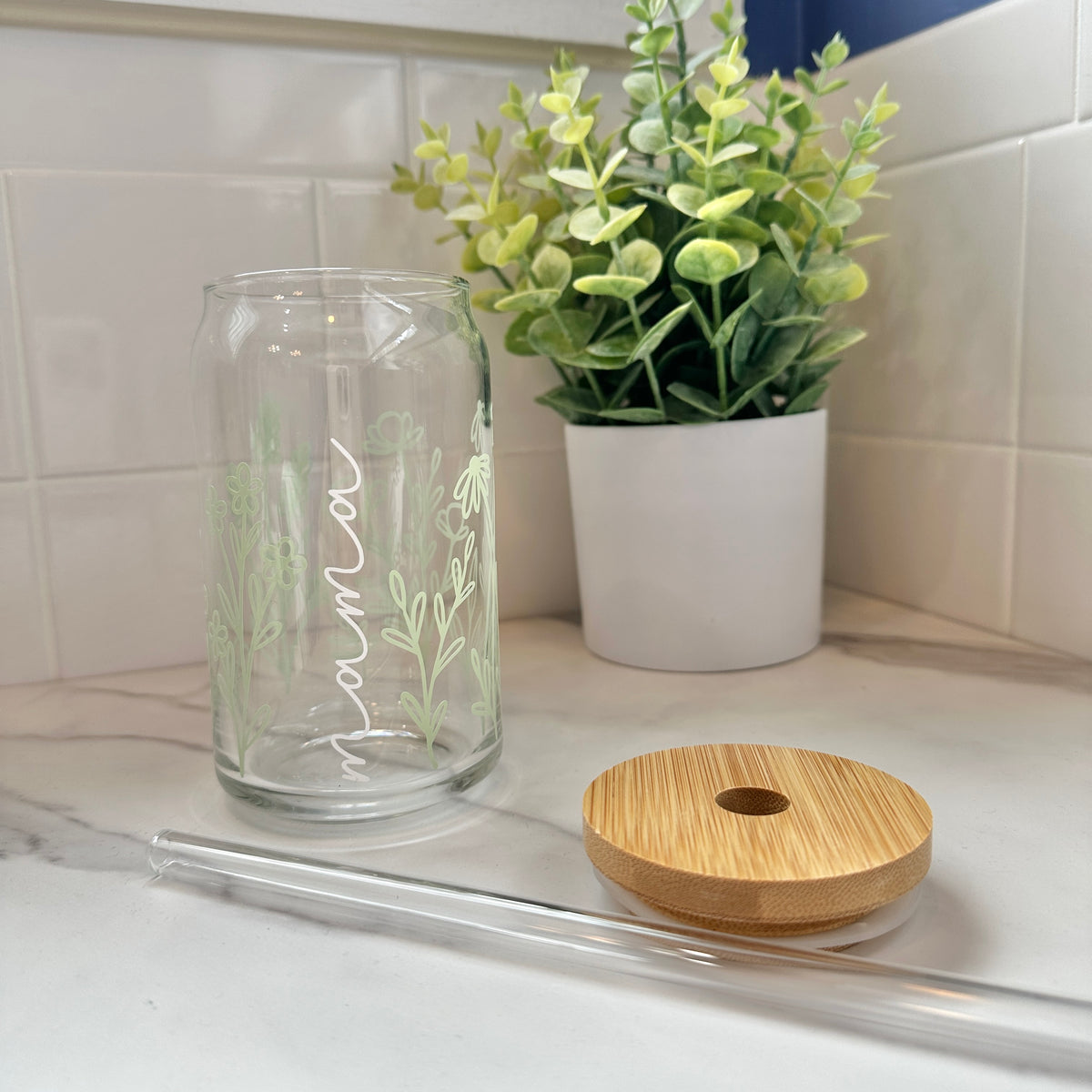 glass cup with flowers and the word "mama" and a bamboo top and glass straw