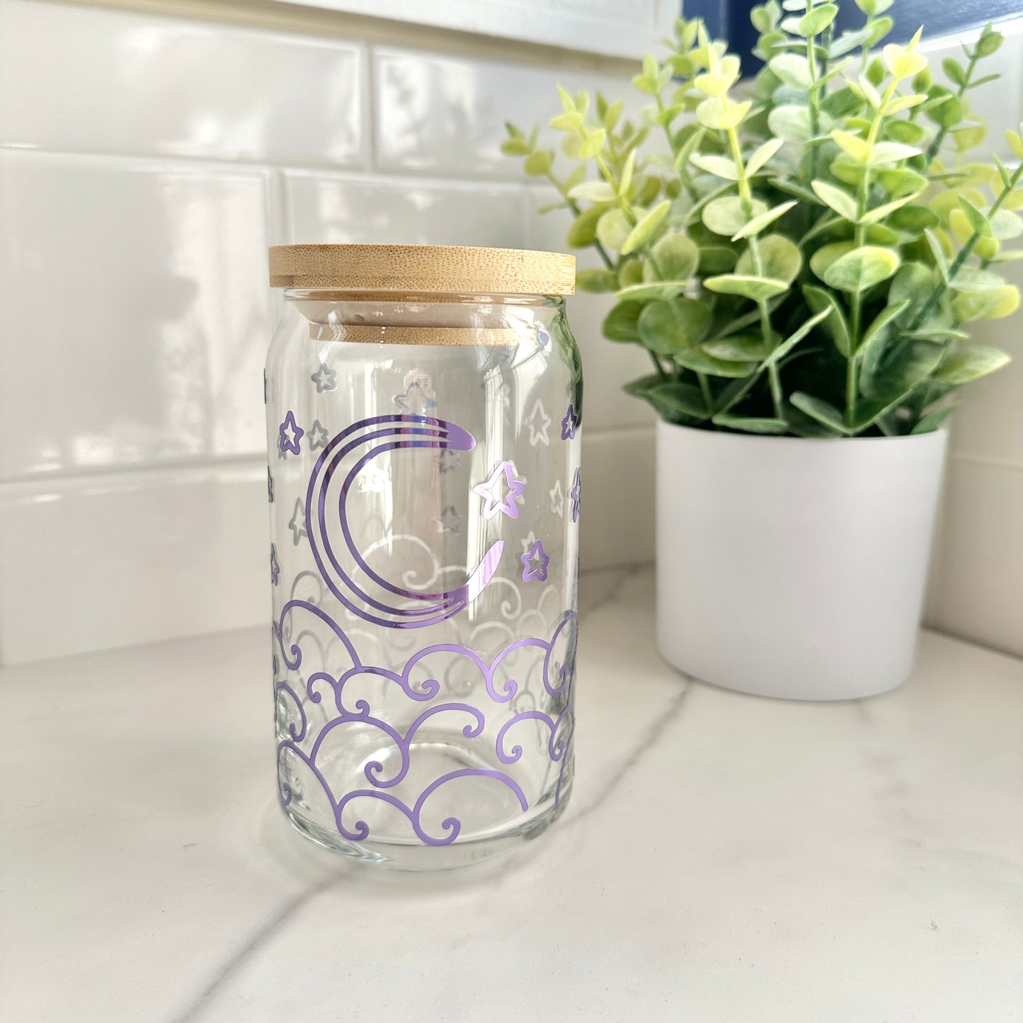 moon and waves glass cup on a countertop next to a small plant