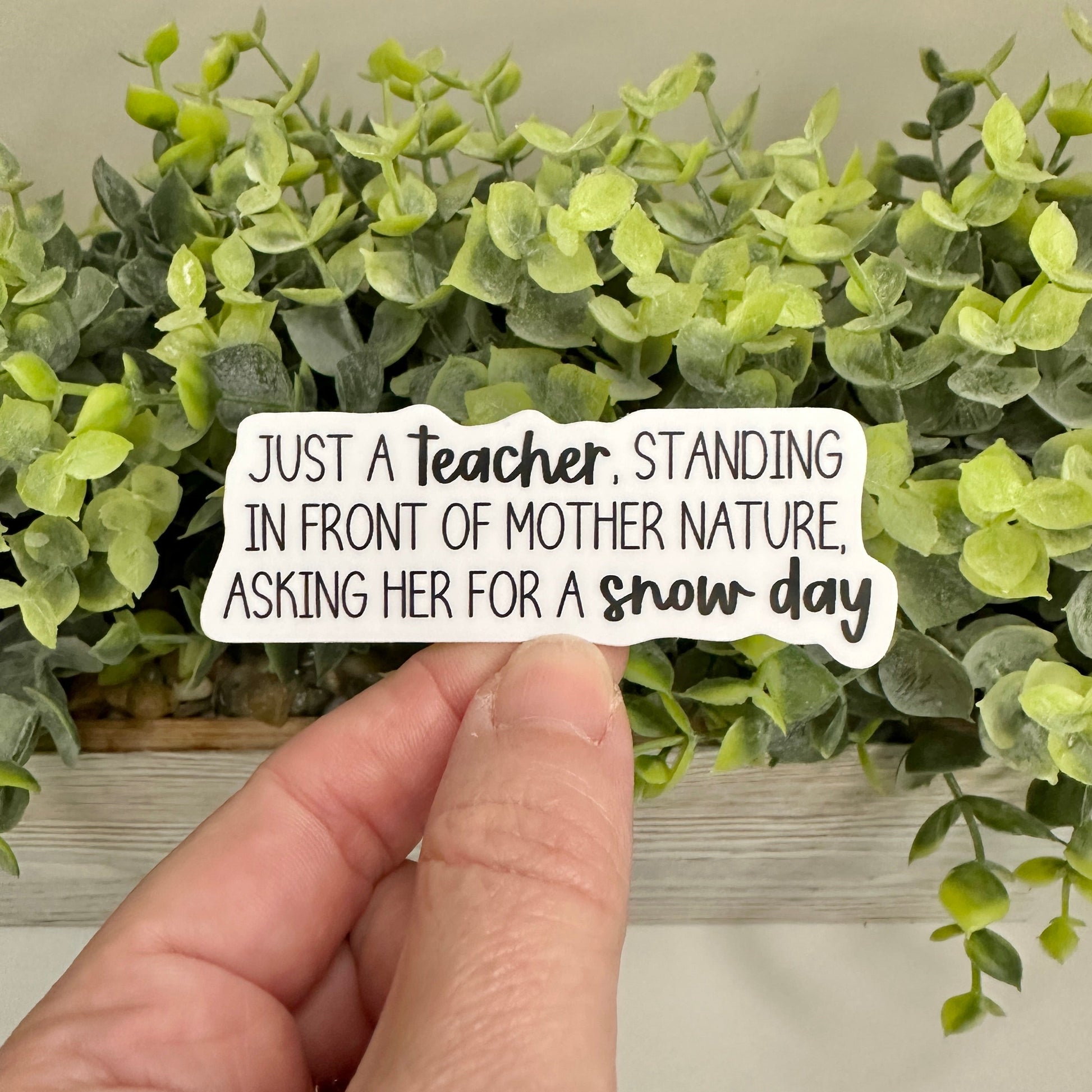 hand holding a teacher snow day sticker