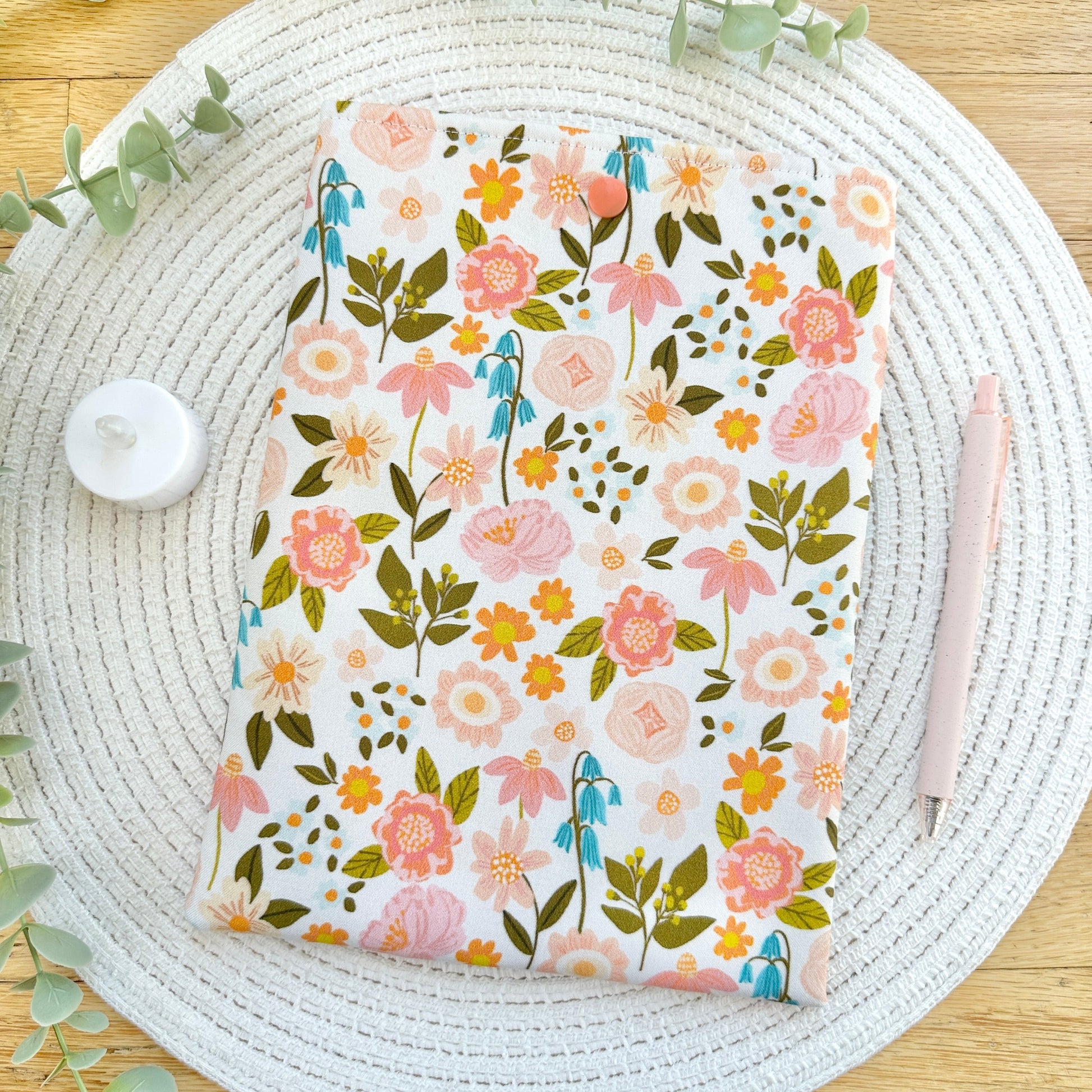 floral book sleeve on woven mat with decorative elements